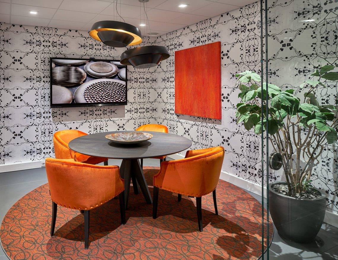 Oranje velours stoelen rond een tafel